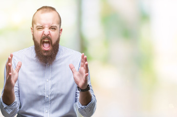 Young caucasian hipster man over isolated background crazy and mad shouting and yelling with aggressive expression and arms raised. Frustration concept.