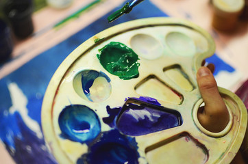 artist holding easel with paint