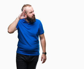 Young caucasian hipster man wearing blue shirt over isolated background smiling with hand over ear listening an hearing to rumor or gossip. Deafness concept.