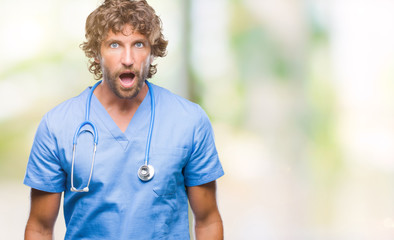 Fototapeta na wymiar Handsome hispanic surgeon doctor man over isolated background afraid and shocked with surprise expression, fear and excited face.