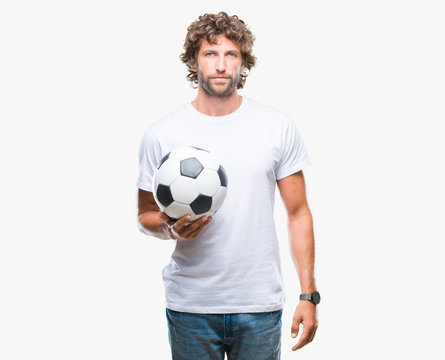 Handsome hispanic man model holding soccer football ball over isolated background with a confident expression on smart face thinking serious