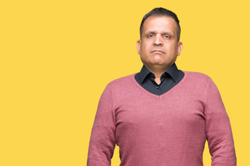 Middle age arab man over isolated background with serious expression on face. Simple and natural looking at the camera.