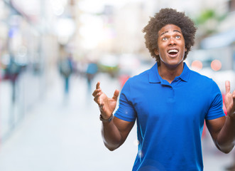 Afro american man over isolated background crazy and mad shouting and yelling with aggressive expression and arms raised. Frustration concept.