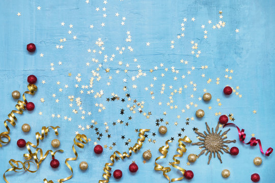 Colorful holiday decoration on blue background. Top view, copy space. Flat lay.