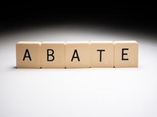 Abate word made with wooden blocks on white table with elegant shadow on background. 