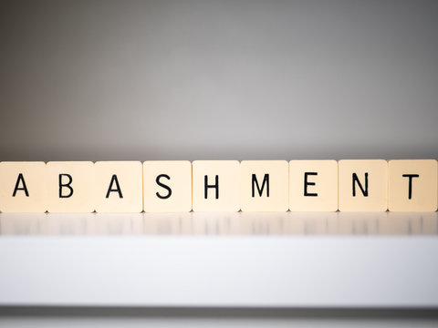 Closeup of abashment word on white table.