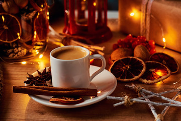 Cup of coffee in festive decorations with a fairy garland lights
