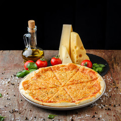 Pizza with ingredients on a wooden background, close up