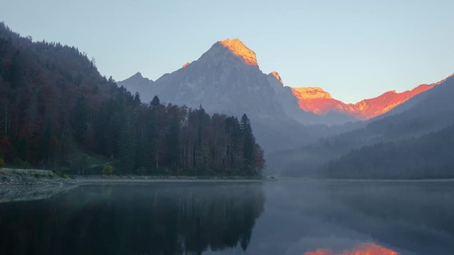 Peaceful autumn view on Obersee lake in Swiss Alps. Clear sky and mountains reflections in clear water. Nafels village, Switzerland. Timelapse video