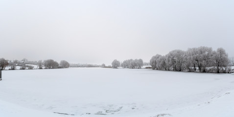 Fototapeta na wymiar panorama Winter view Trees covered with frost grow on the shores of the lake.
