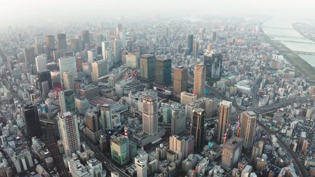 Panning aerial view over Osaka city with many skyscrapers in the morning. Osaka is the capital city of Osaka Prefecture, the second largest metropolitan area in Japan.
