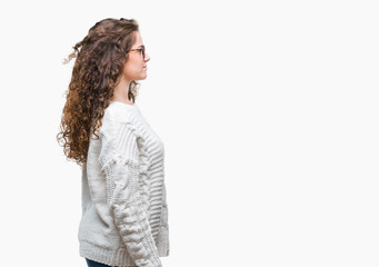 Beautiful brunette curly hair young girl wearing winter sweater over isolated background looking to side, relax profile pose with natural face with confident smile.