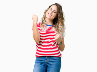 Obraz na płótnie Canvas Beautiful young blonde woman over isolated background very happy and excited doing winner gesture with arms raised, smiling and screaming for success. Celebration concept.