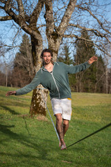 junger mann auf slackline in der sonnigen natur