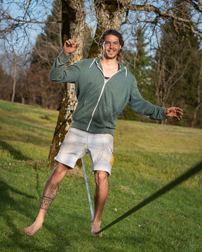 junger mann auf slackline in der sonnigen natur