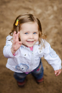 Cute Girl Waving And Smiling At Camera, Shot From Above