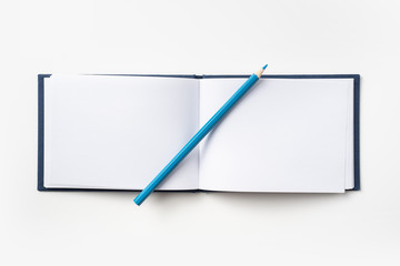 Top view of blue hardcover notebook and pencil