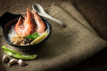 Rice gruel mixed with prawn and ginger, scallion slice and deep fried garlic and black pepper in...