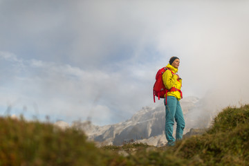Naklejka premium Pretty, young female hiker walking in high mountains (shallow DOF)