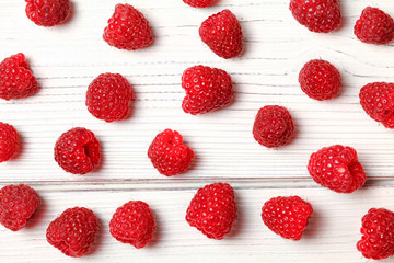 Tabletop view, raspberries spilled on white boards.