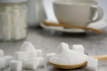 Sugar in wooden spoon for putting in coffee, adding sweetness - image