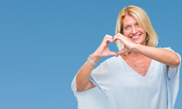 Middle age blonde business woman over isolated background smiling in love showing heart symbol and shape with hands. Romantic concept.
