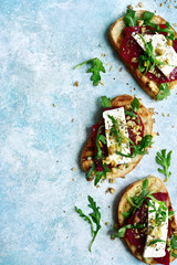 Toasts with beet root, feta cheese, arugula and walnut.Top view with copy space.