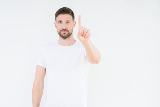 Young handsome man wearing casual white t-shirt over isolated background Pointing with finger up and angry expression