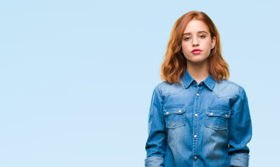 Young beautiful woman over isolated background with serious expression on face. Simple and natural...
