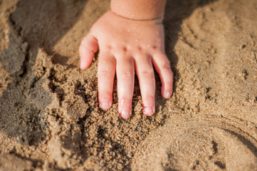 Closeup of a child hand, playing in the sand