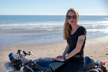 Fototapeta na wymiar Mujer con motocicleta en la playa