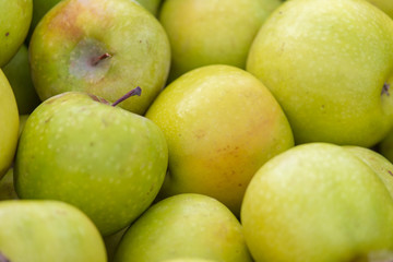 Green apples in the market as background