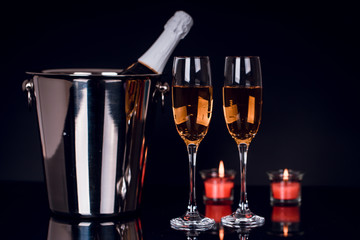 Champagne bottle with two wine glasses and candles