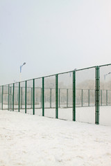 Tennis court fence in the snow