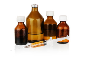four brown bottles and a filled syringe on a white isolated background