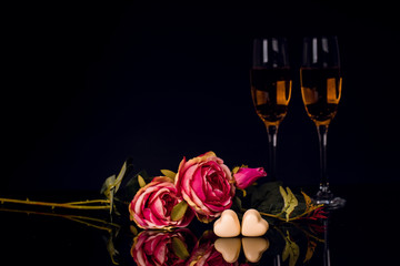 Two glasses of champagne, roses heart shape chocolates