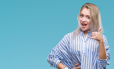 Young blonde woman over isolated background smiling doing phone gesture with hand and fingers like talking on the telephone. Communicating concepts.