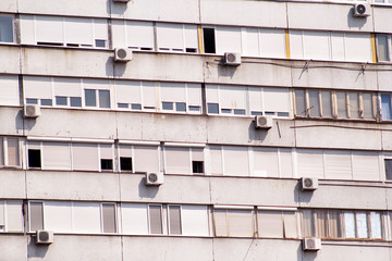 Communist socialist architecture. Architectural detail and pattern of social residential of apartments. Portrait of socialist-era housing district, city building facade. Old apartment windows in city.