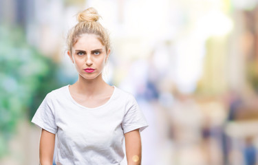 Young beautiful blonde woman wearing white t-shirt over isolated background skeptic and nervous, frowning upset because of problem. Negative person.