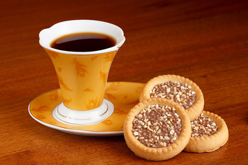 A cup of coffee stands on the table with delicious sweets