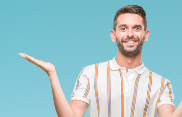 Young handsome man over isolated background clueless and confused expression with arms and hands...