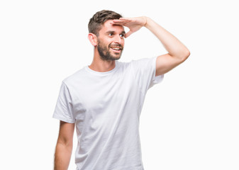 Naklejka premium Young handsome man over isolated background very happy and smiling looking far away with hand over head. Searching concept.