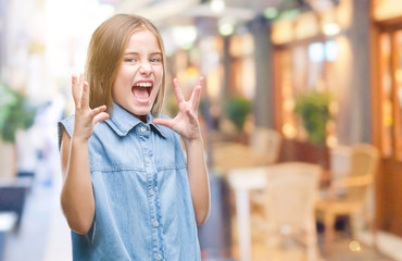 Young beautiful girl over isolated background crazy and mad shouting and yelling with aggressive expression and arms raised. Frustration concept.