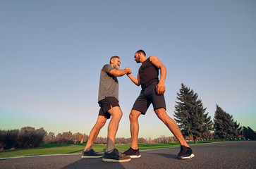 The two opponents holding hands in the park