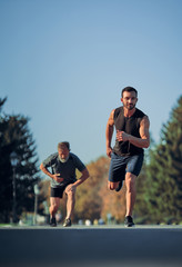 Fototapeta premium The two sportsmen running marathon in the beautiful park