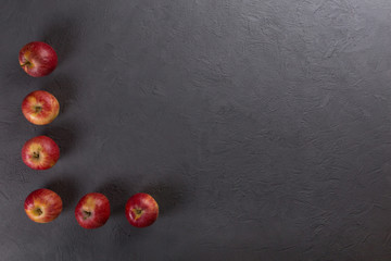 Red ripe apples on black background. Background with copy space top view.