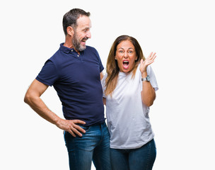 Middle age hispanic casual couple over isolated background celebrating mad and crazy for success with arms raised and closed eyes screaming excited. Winner concept