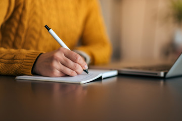 Close-up image of a girl making notes. Copy space.