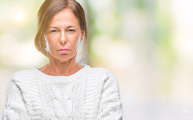 Middle age senior hispanic woman wearing winter sweater over isolated background skeptic and nervous, disapproving expression on face with crossed arms. Negative person.