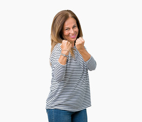 Obraz na płótnie Canvas Beautiful middle age woman wearing stripes sweater over isolated background Ready to fight with fist defense gesture, angry and upset face, afraid of problem